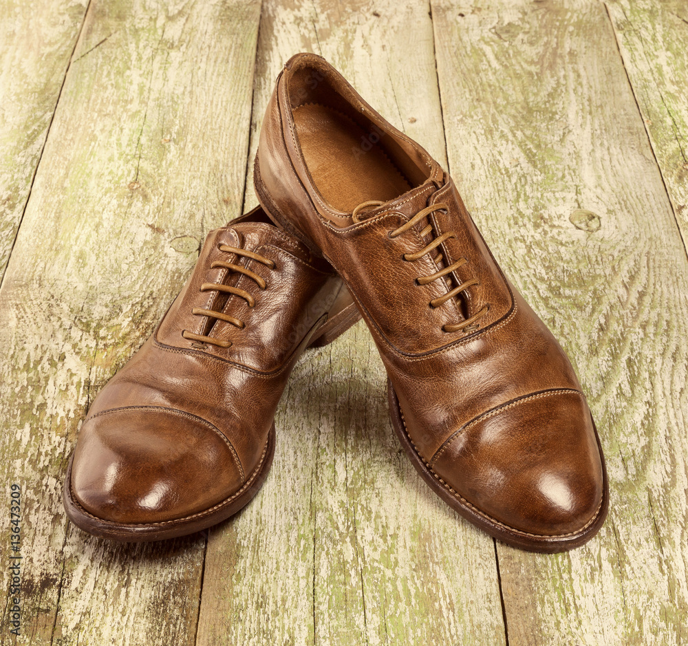 Men's classic brown leather shoes on the wood floor. Men Brown Shoes.