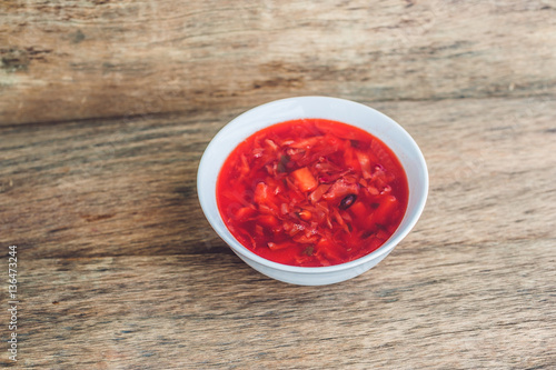 Traditional Ukrainian Russian vegetable borscht soup on the old wooden background photo