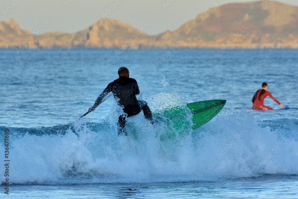 Un homme sportif pratique le paddle et le surf à Perros-Guirec en Bretagne Un homme sportif pratique le paddle et le surf à Perros-Guirec en Bretagne