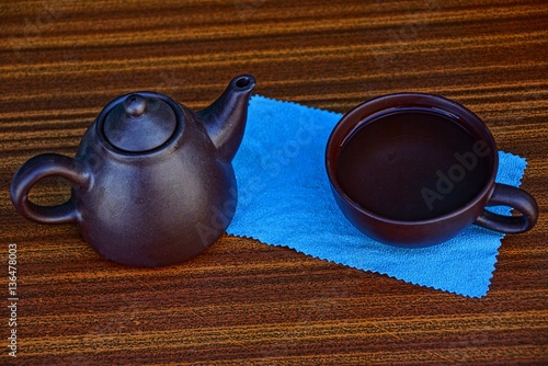 Чайник и чашка на голубой салфетке