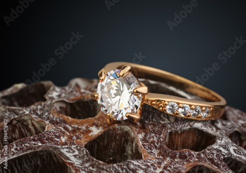 golden jewellery ring with big diamond on dry Lotus flower, macr