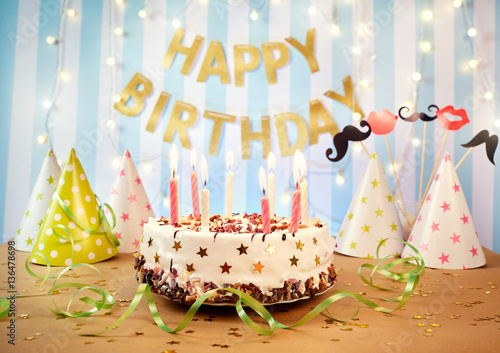 Photography Happy birthday cake with candles on the background of garlands and letters
