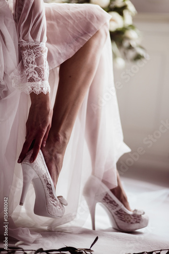 beautiful girl in wedding boudoir dress wears white shoes close-up