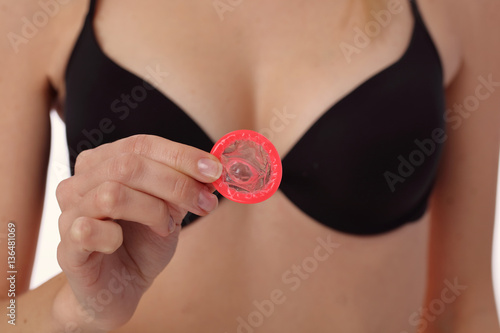 Female hand holding condom. Prevention of sexually transmitted diseases. Health care and STD prevention concept. photo