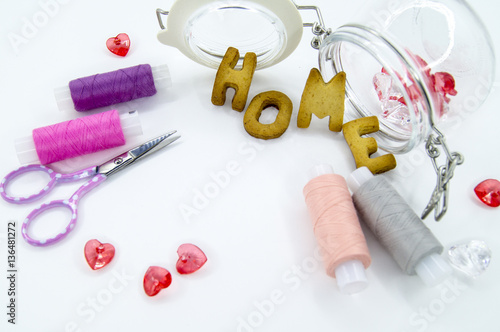 Colorful sewing threads with the scissors, beads and cookies