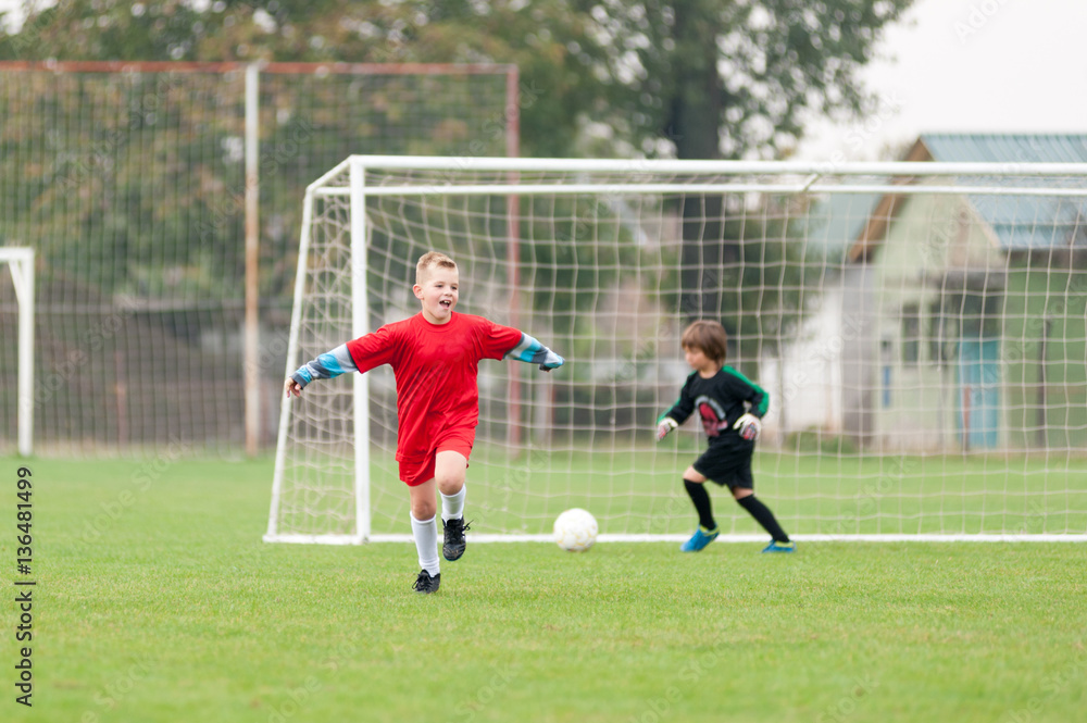 Young football player in a red jersey celebrates goal