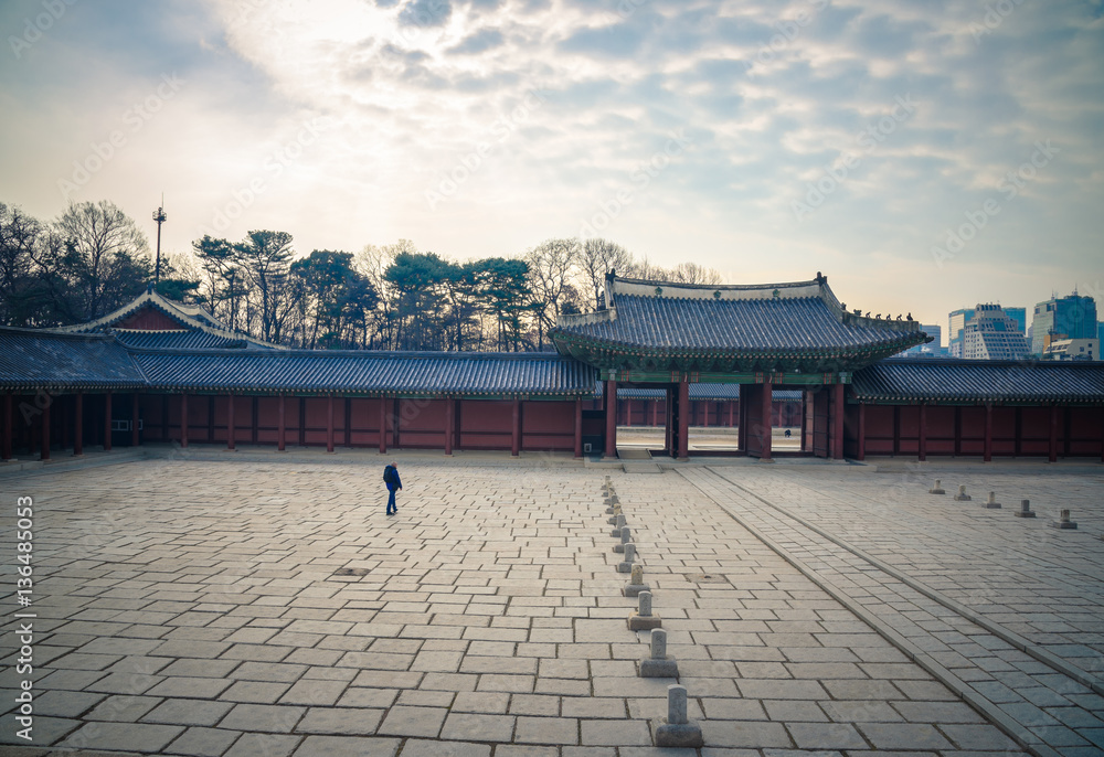 A man walk alone in a sqaure of Changdeokgung Palace in Seoul