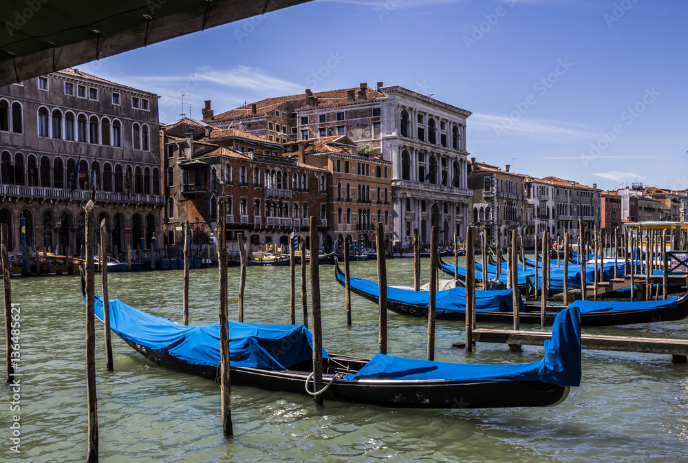 Grand Canal at one summer day, mooring gondolas at berthes, Venice, Italy