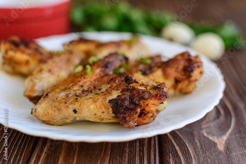 Chicken wings with onion on wooden background
