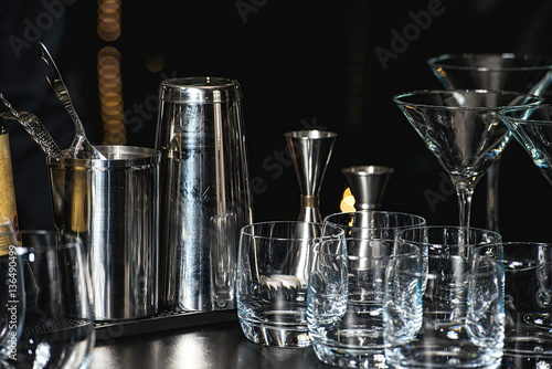 Glasses for a margarita, martini, grog and liqueur on a bar at restaurant, against the bar bar wall background.