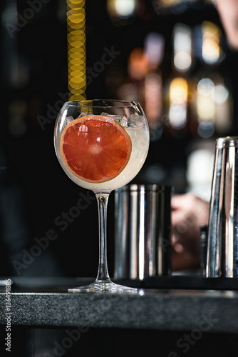 refreshing ruby red coctail with grape fruit isolated on a bar b photo