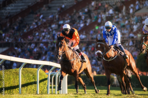 Fotografia, Obraz Two jockeys during horse races on his horses going towards finish line