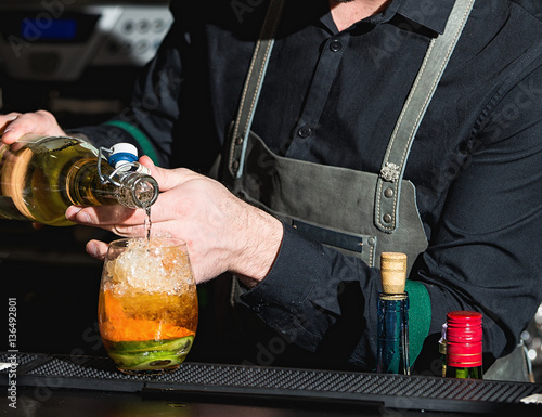 bartender making refreshing coctail with cucumber isolated on a bar background photo