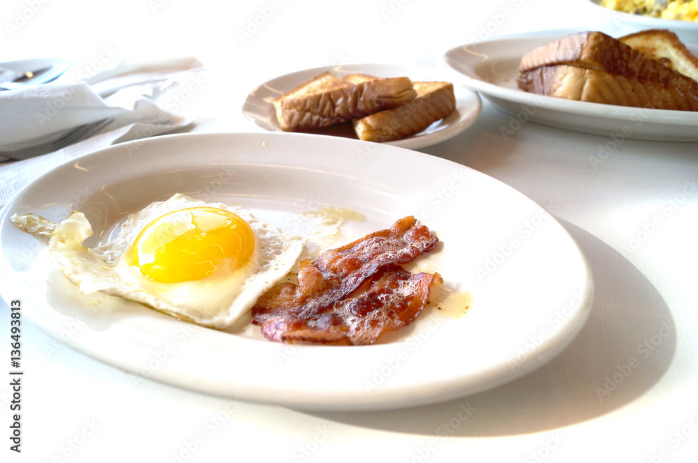 American traditional breakfast with eggs, bacon and white toast American traditional breakfast with eggs, bacon and white toast