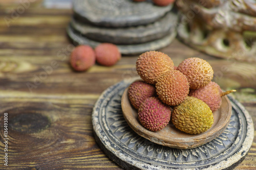 Lychees on wooden background - exotic and tropical fruit