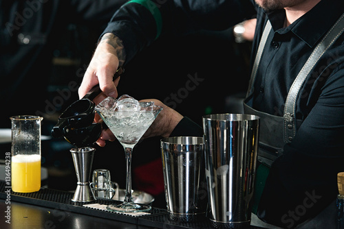 bartender making relaxing coctail on a bar background photo