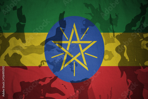 flag of ethiopia on the khaki texture . military concept