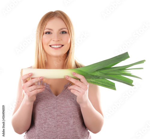 Young woman holding leek on white background