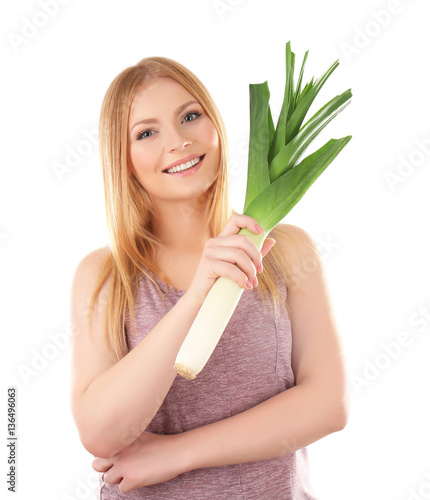 Young woman holding leek on white background