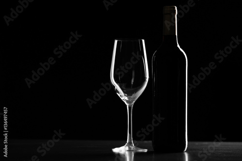 Bottle of wine and glass on black background