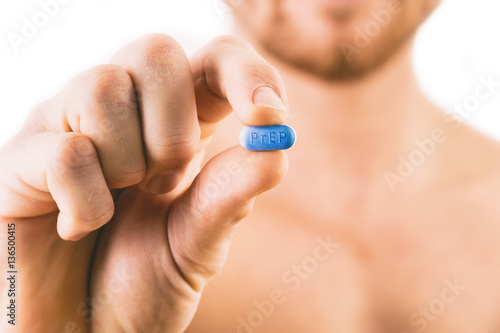 Man holding a pill used for Pre-Exposure Prophylaxis (PrEP) to p photo