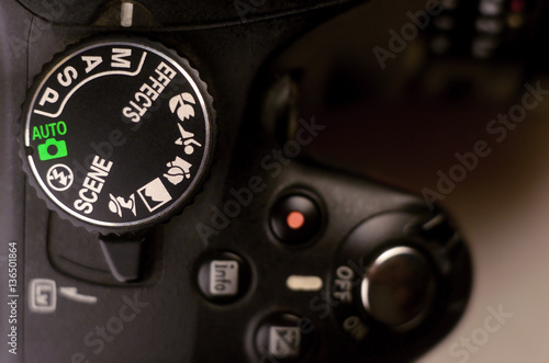 Close-up macro shot of a modern digital SLR camera. Detailed photo of black camera body with buttons to control and switch shooting modes photo