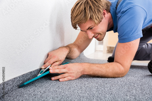 Fotografie Craftsman Cutting Carpet With Cutter