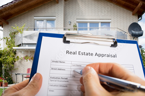Person Hand Filling Real Estate Appraisal Document photo