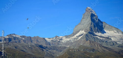 Helicopter is external load flying near Matterhorn mountain in Z