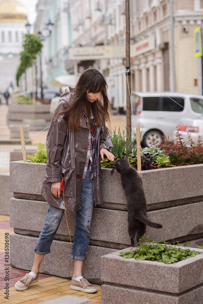 beautiful woman walking with a cat in the city beautiful woman walking with a cat in the city
