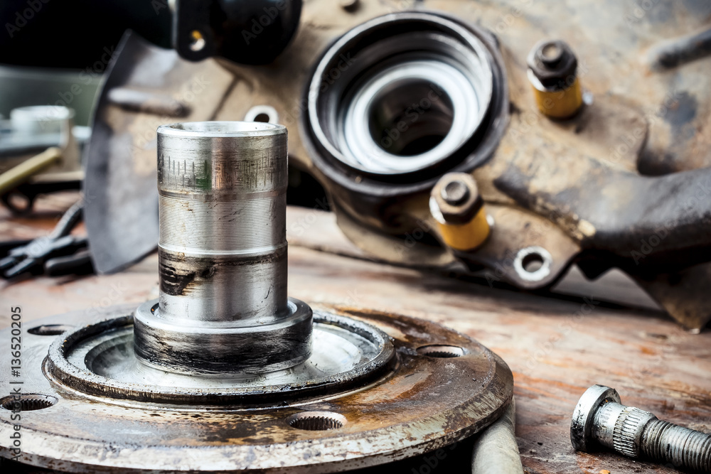 Old, oiled wheel hub lies on a wooden table Old, oiled wheel hub lies on a wooden table