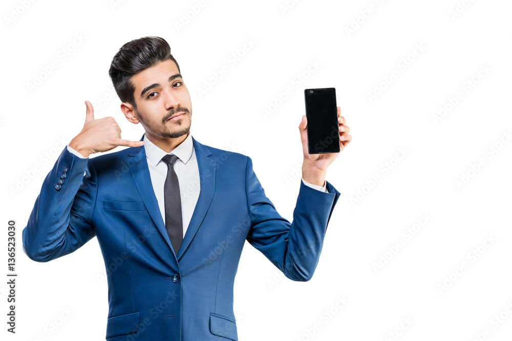 Young attractive man in a blue suit with the phone shows a hand gesture call me Young attractive man in a blue suit with the phone shows a hand gesture call me
