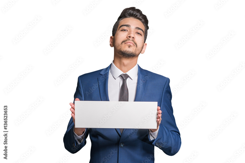 Young attractive man in a blue suit holding a white sign on a white background. Isolated Young attractive man in a blue suit holding a white sign on a white background. Isolated
