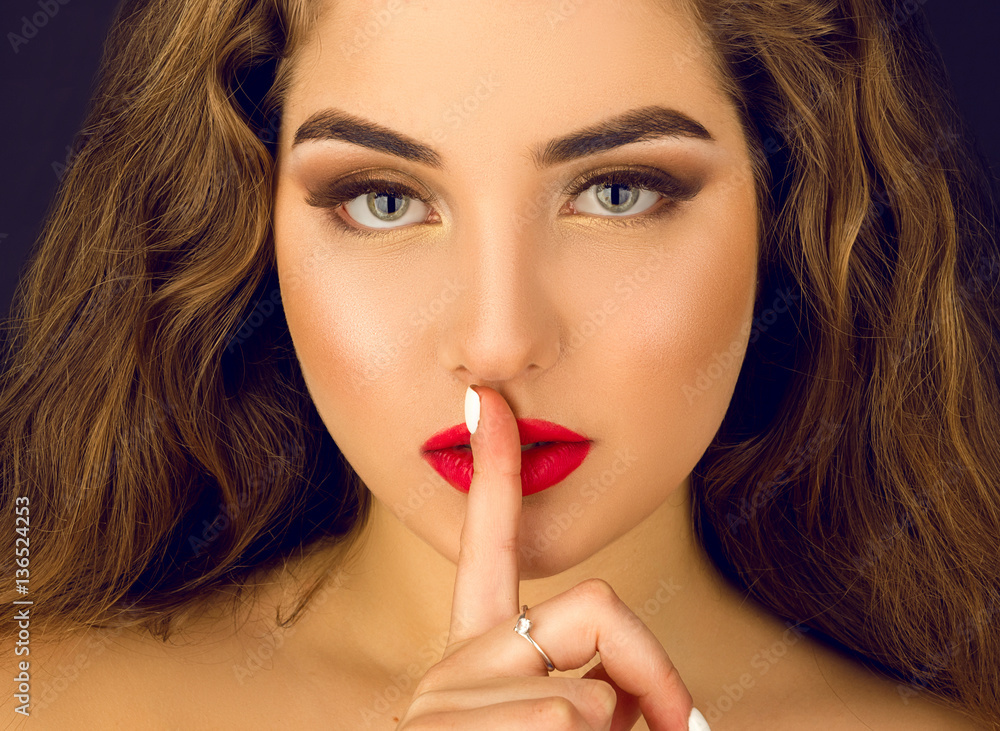 fashion portrait of a girl with a finger pressed to his lips fashion portrait of a girl with a finger pressed to his lips