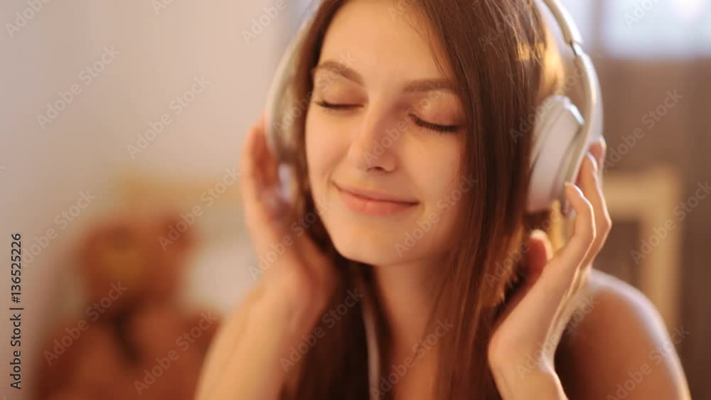 Portrait of young attractive girl in urban background listening to music with headphones 4k 20s Portrait of young attractive girl in urban background listening to music with headphones 4k 20s