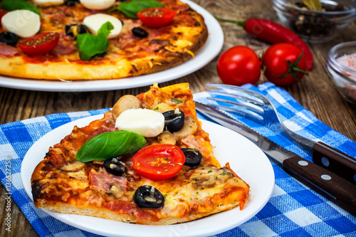 Italian pizza with ham  cheese  mushrooms  tomatoes and mozzarel
