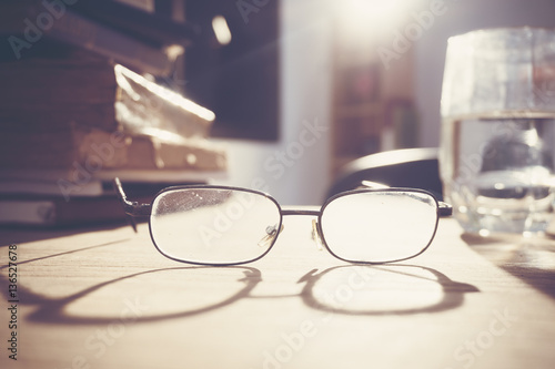 glasses and book on wood table, education concept