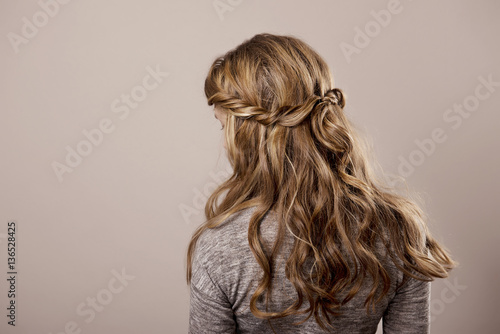 head of a woman with curly hair on gray isolated background