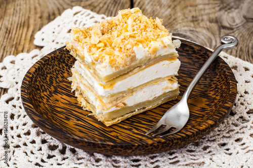 Portion cake of puff pastry with vanilla butter cream photo