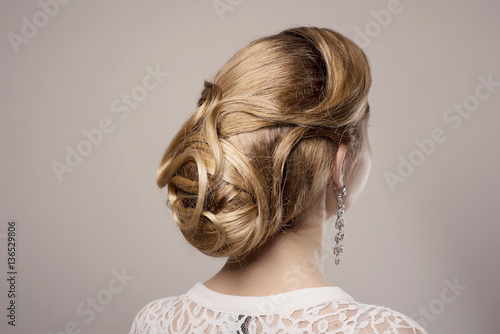 head of woman with hair in bun on gray isolated background