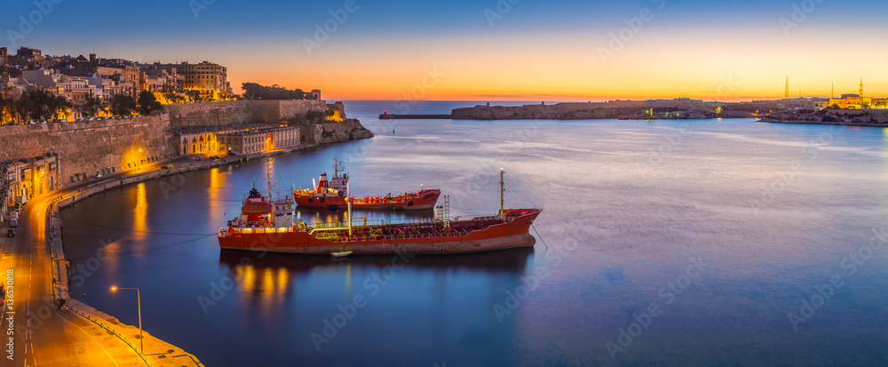 Valletta, Malta - Panoramic skyline view of Valletta and the Grand Harbor on a beautiful summer morning minutes before sunrise with ships