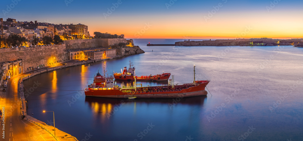 Valletta, Malta - Panoramic skyline view of Valletta and the Grand Harbor on a beautiful summer morning minutes before sunrise with ships