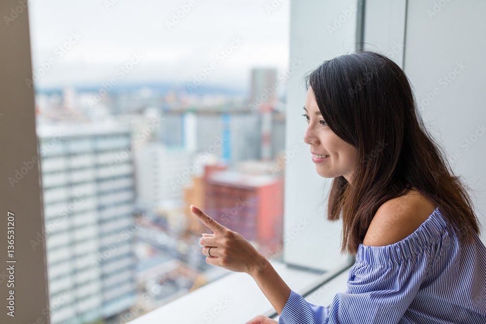 Fototapeta premium Woman looking though the window