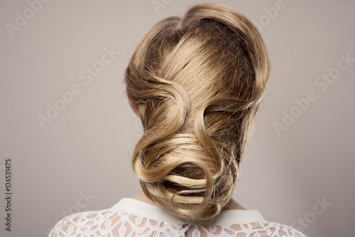 head of woman with hair in bun on gray isolated background
