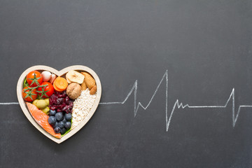 Healthy food in heart and cardiograph on blackboard medical abstract concept

