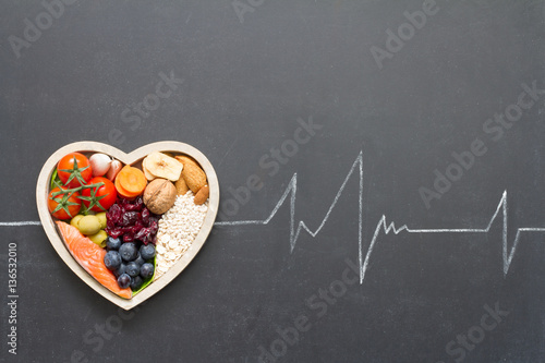 Healthy food in heart and cardiograph on blackboard medical abstract concept

