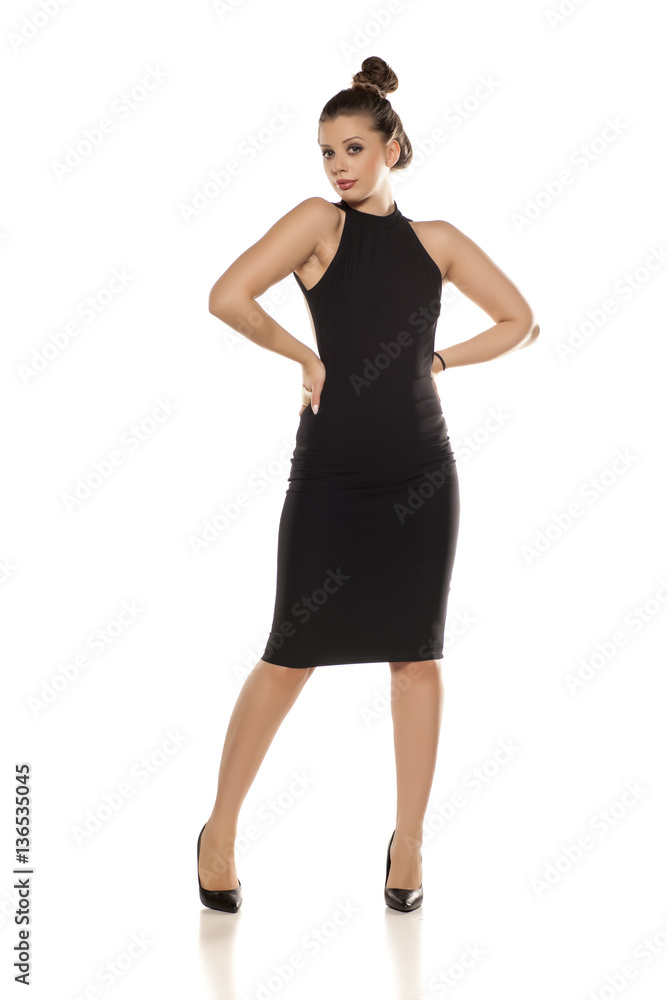 Fototapeta premium young woman in tighit black dress on white background