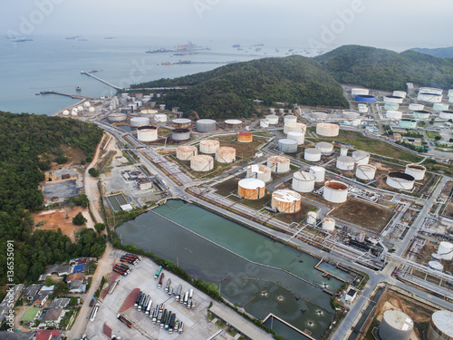 Oil tank storage field in hill with oil terminal jetty in aerial view