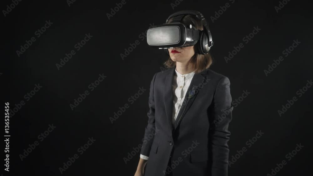 Woman in suit uses virtual reality goggles. Virtual reality helmet with headphones. 4K
Woman uses virtual interface. High-tech devices. The movement of the hands on a black background. Woman in suit uses virtual reality goggles. Virtual reality helmet with headphones. 4K
Woman uses virtual interface. High-tech devices. The movement of the hands on a black background.