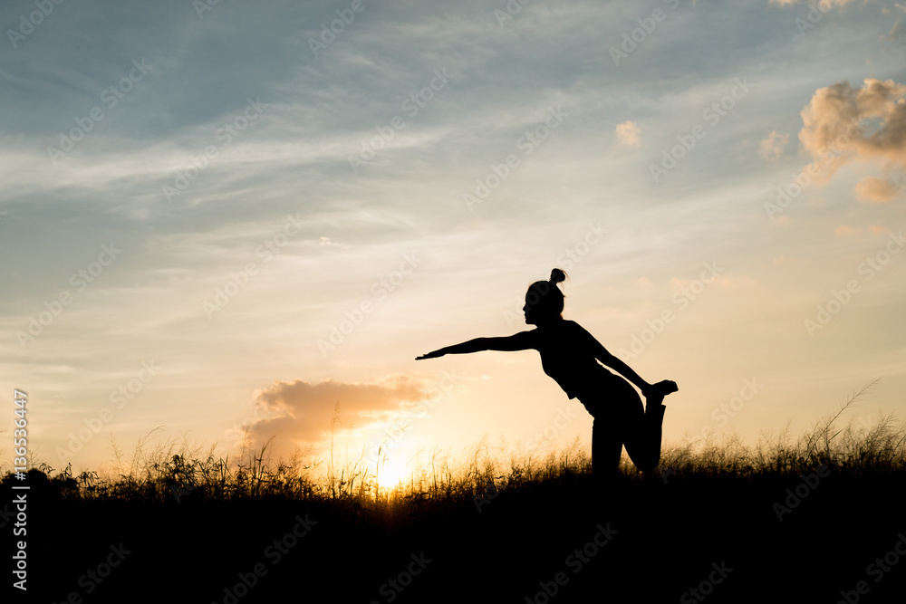 Women exercising in Meadow at sunset